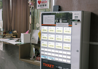 7月からの有料化を前に、公民館の窓口近くに設置された券売機＝中央公民館で6月21日に写す