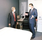 高山市長（左）に客室を説明する岡村代表取締役