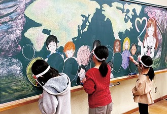 黒板に絵を描く生徒