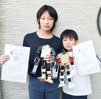 ロボットと賞状を手にする兄の修一さん（左）と弟の大知さん