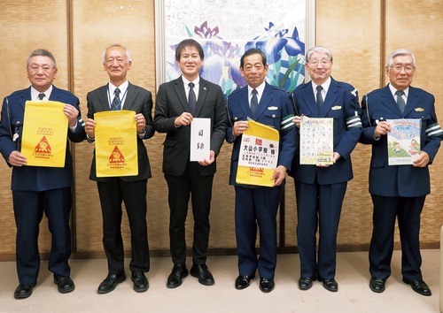 ランドセルカバーを寄贈する飯塚会長（中央右）と副会長ら