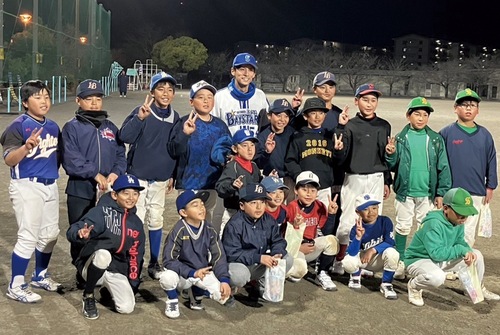 交流試合に参加した児童らと元プロ野球選手の寺田さん（後列中央）