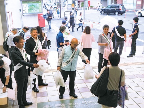 伊勢原駅前で啓発グッズを手渡す様子