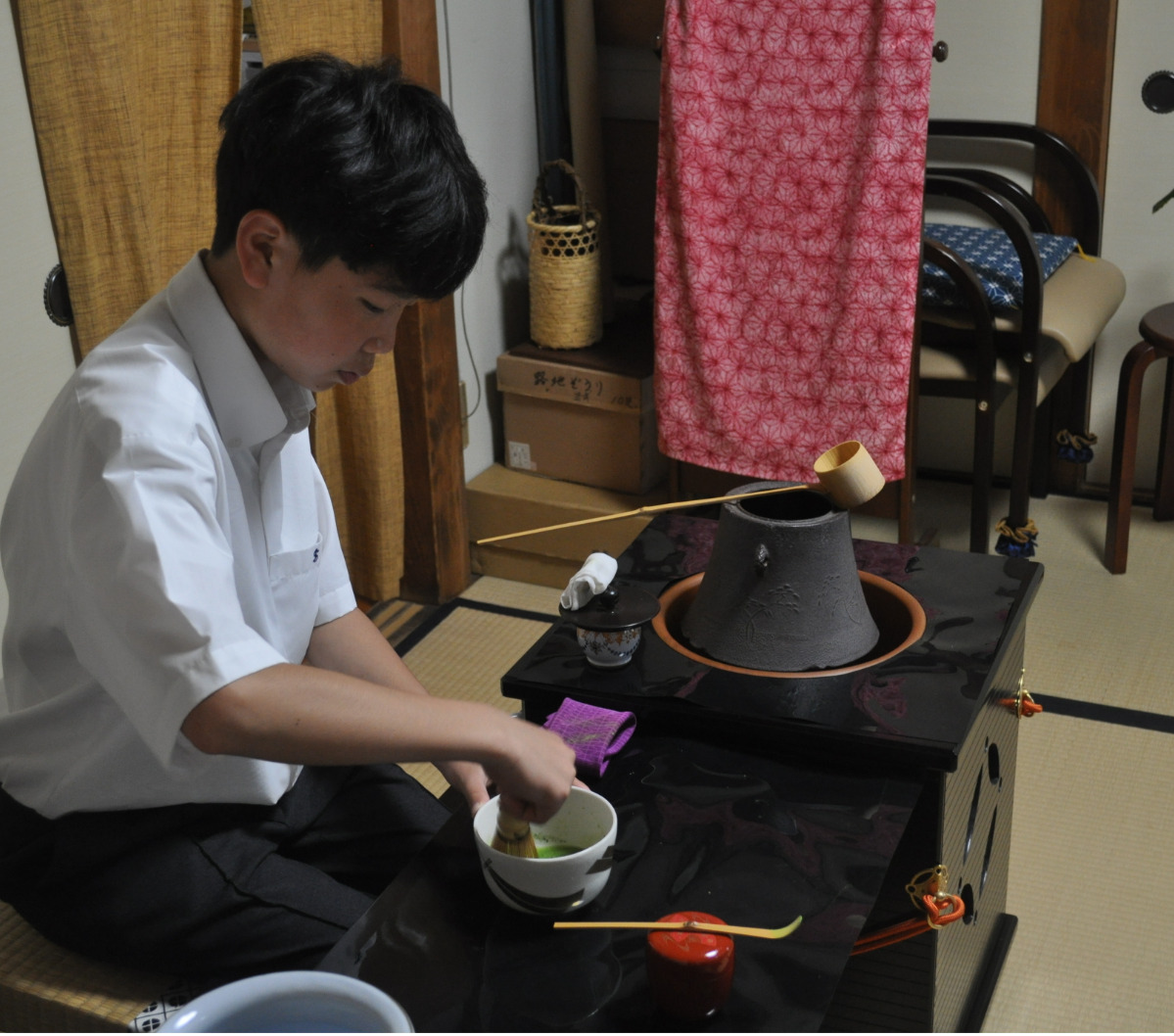 真剣な表情で茶筅を振る生徒