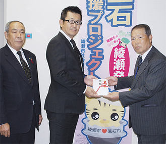 中村社長（中央）と志田所長（左）から寄付を受け取る増田協議会会長（右）