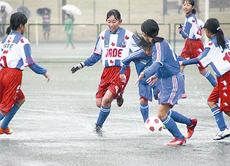 雨の中、白熱の試合を繰り広げる選手たち