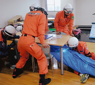 容態観察と保温処置をして被災者を救出する訓練