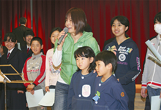 子どもたちとともに歌を披露する白井貴子さん（中央）