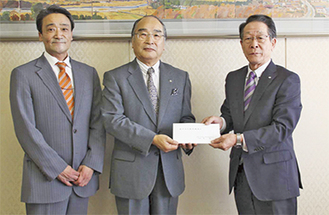小野沢町長に義援金を手渡す堀理事長（中央）と山本常務理事（左）