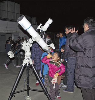 天体望遠鏡で月を観察する子どもたち