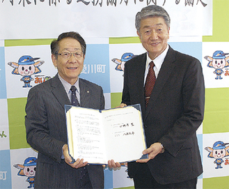 協定書を手にする小野澤町長（左）と八木理事長
