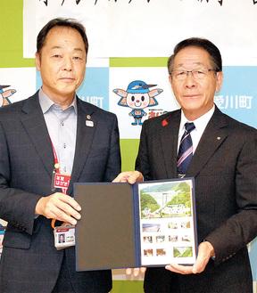 小野澤町長に切手を手渡す村野経営管理本部長（左）