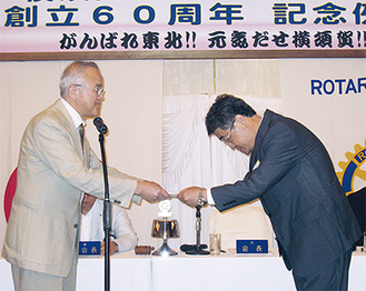 記念例会で義援金を手渡す横須賀ＲＣの岡会長（左）
