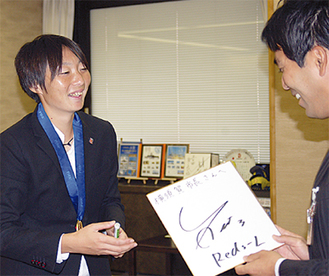 市長に色紙をプレゼントする矢野選手