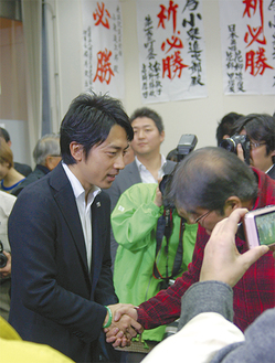 当確の知らせを受け、事務所で支持者と握手を交わす小泉氏（＝16日）