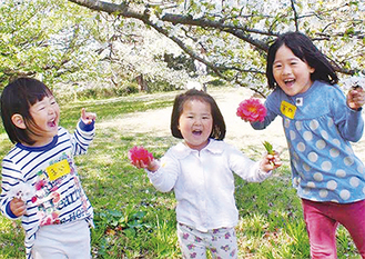 活動中にお花摘み　満面の笑みを見せて遊ぶ子ども