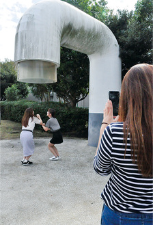 平成町にある蛇口を想起させるモニュメントで“インスタ映え”を意識した写真を撮影する関学生