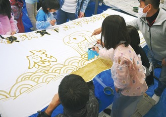 青年部会のメンバーと入所する子どもたちで色塗りの共同作業