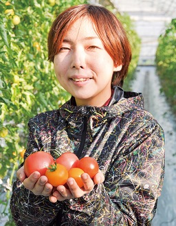 採れたてのトマトを大事そうに持つ永野さん