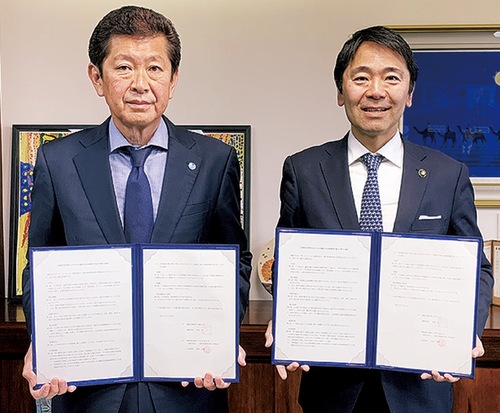 松尾市長（右）と協定書を交わす小林副理事