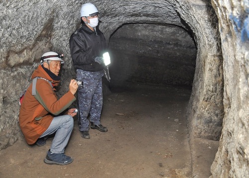 海自横須賀教育隊の敷地内にある地下壕を調査する佐藤さん（左）。終戦間際に基地の地下化を目的に掘られた
