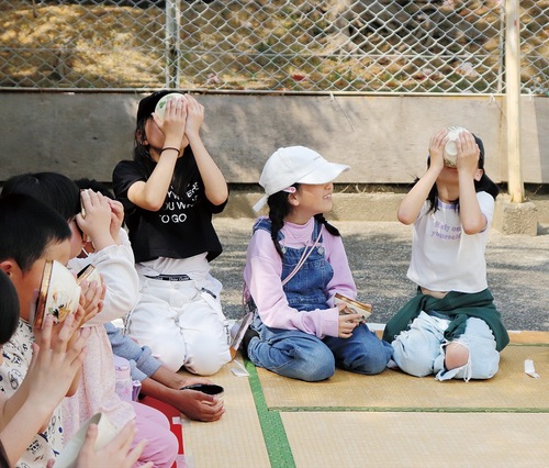 教えられた作法でお茶を飲む児童ら