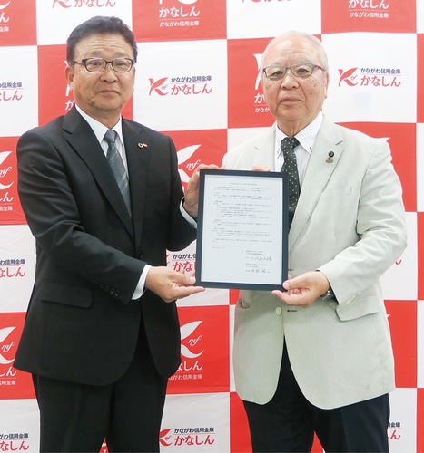 協定書を手にする片岡理事長（左）と小川会長
