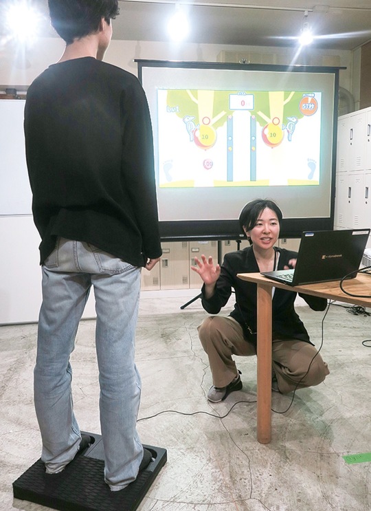 測定機の上に立ち、足把持力でゲームをプレイ
