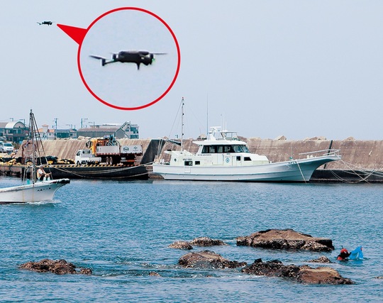 実証実験で密漁行為を監視するドローン（左上）