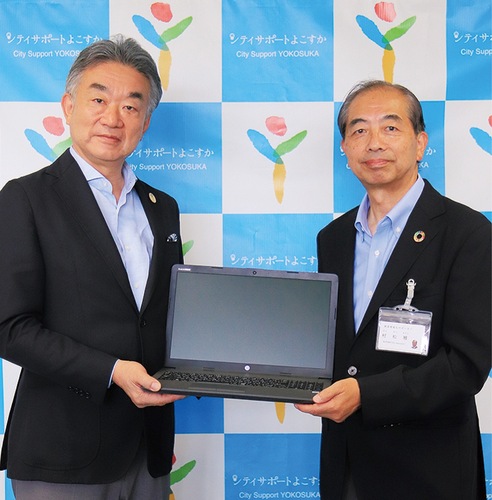 ＰＣを寄贈した竹内代表理事(左)