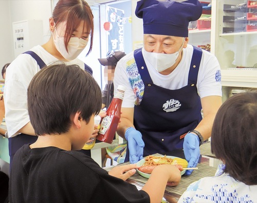 参加した子どもに料理を提供する音さん