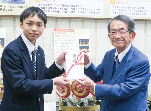 目録を手渡す織茂さん（右）