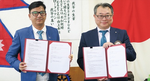 調印した覚書を手にする山下会長（右）