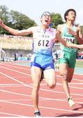 ゴールテープに飛び込み両手を広げる岩野さん