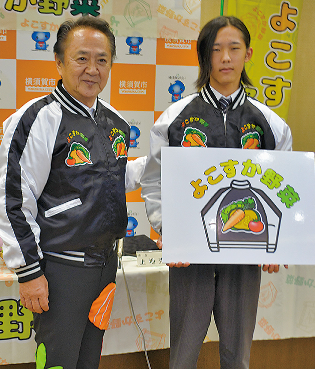 「スカジャンと色とりどりの野菜を組み合わせてデザインした」と宮地さん=写真右