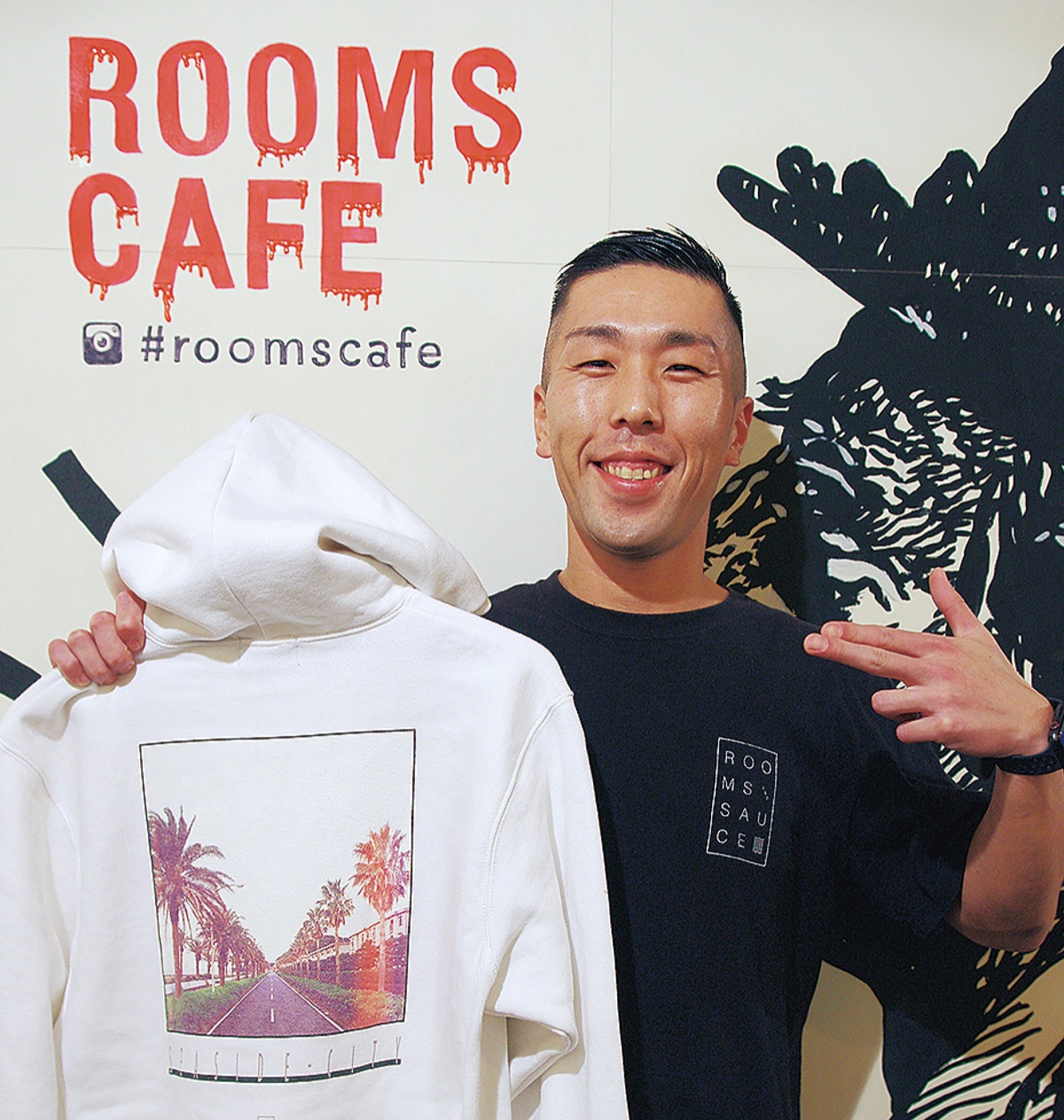 新作パーカーを手にする中村さん