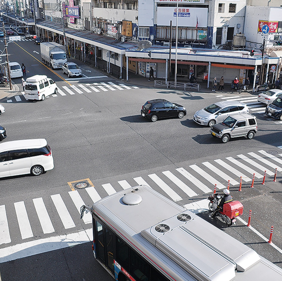 右左折する乗用車やバスなどで混雑する駅前
