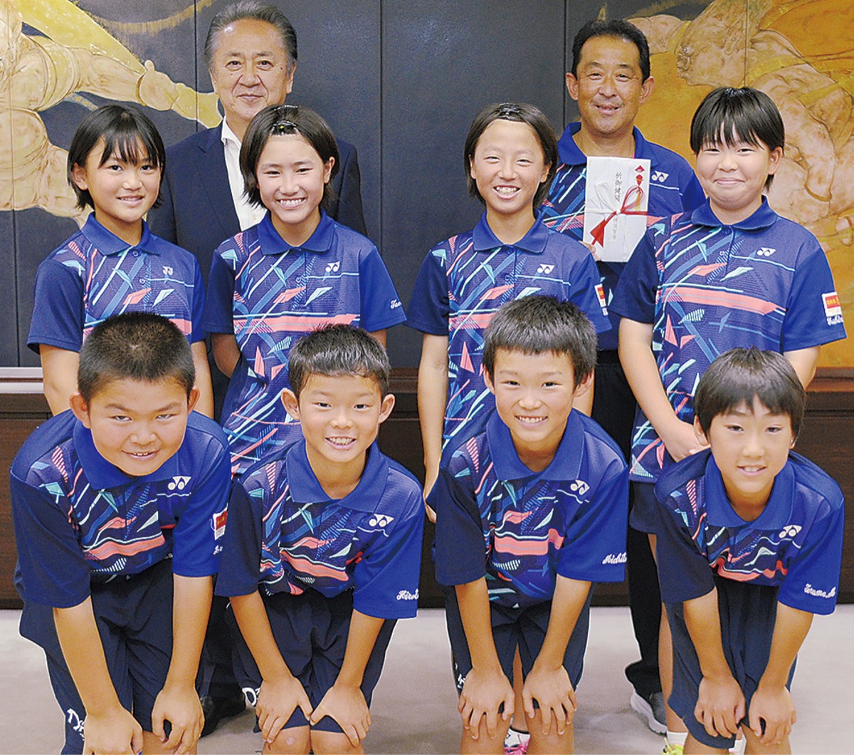 大会へ出場する選手たちと本吉監督(後列右)、上地市長(後列左)