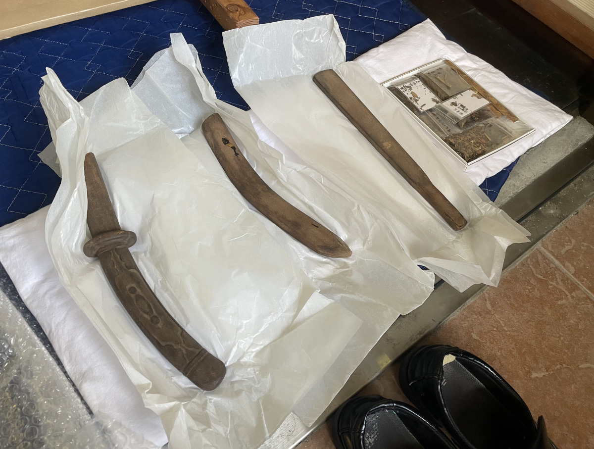 坐像に備えついている笏や太刀。右は今回の修復で生じた破片