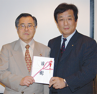 目録を手にする市長と秋本会長（左）