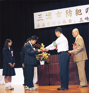 鈴木三崎警察署長から表彰状を受け取る中学生