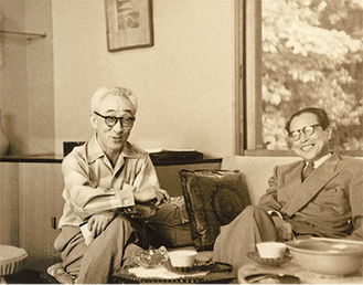 画室で談笑する山口蓬春（左）と吉田五十八《昭和32年（１９５７）》＝同館提供