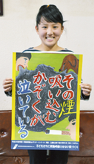 今後、市内各所で掲示されるポスターを持つ鈴木さん