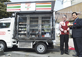 19日、出発式で商品を購入した吉田英男市長