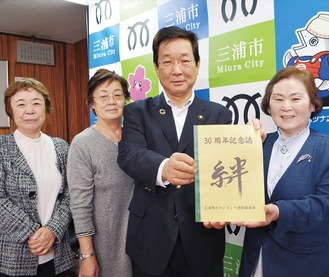 吉田市長（右から2番目）に記念誌を手渡した深瀬会長（右）と会員たち