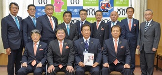 亀井ガバナー(前列左から２番目)と目録を持つ吉田市長、会員ら