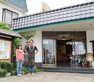 店舗入口に立つ須藤さん(左)と参加事業者の綿引健太さん
