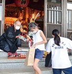 円徳寺の本堂前で村山住職から菓子やジュースを受け取る子どもたち