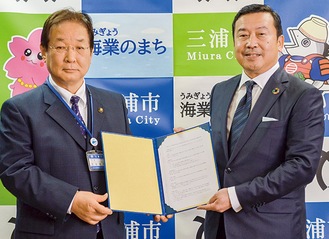 協定書を取り交わす吉田市長（左）と戸谷専務