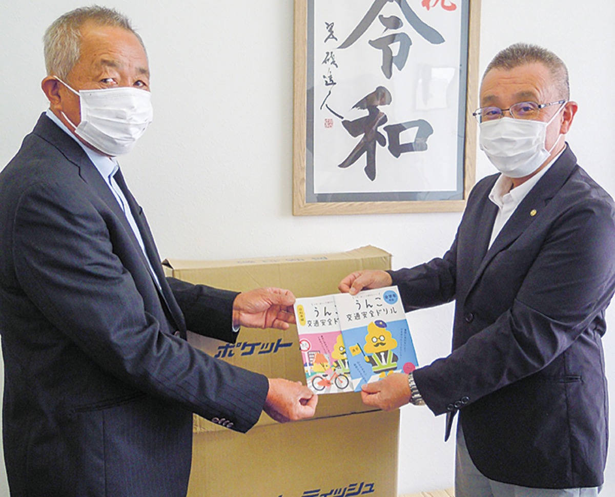 及川教育長にドリルを手渡す高梨会長＝写真左（提供写真）